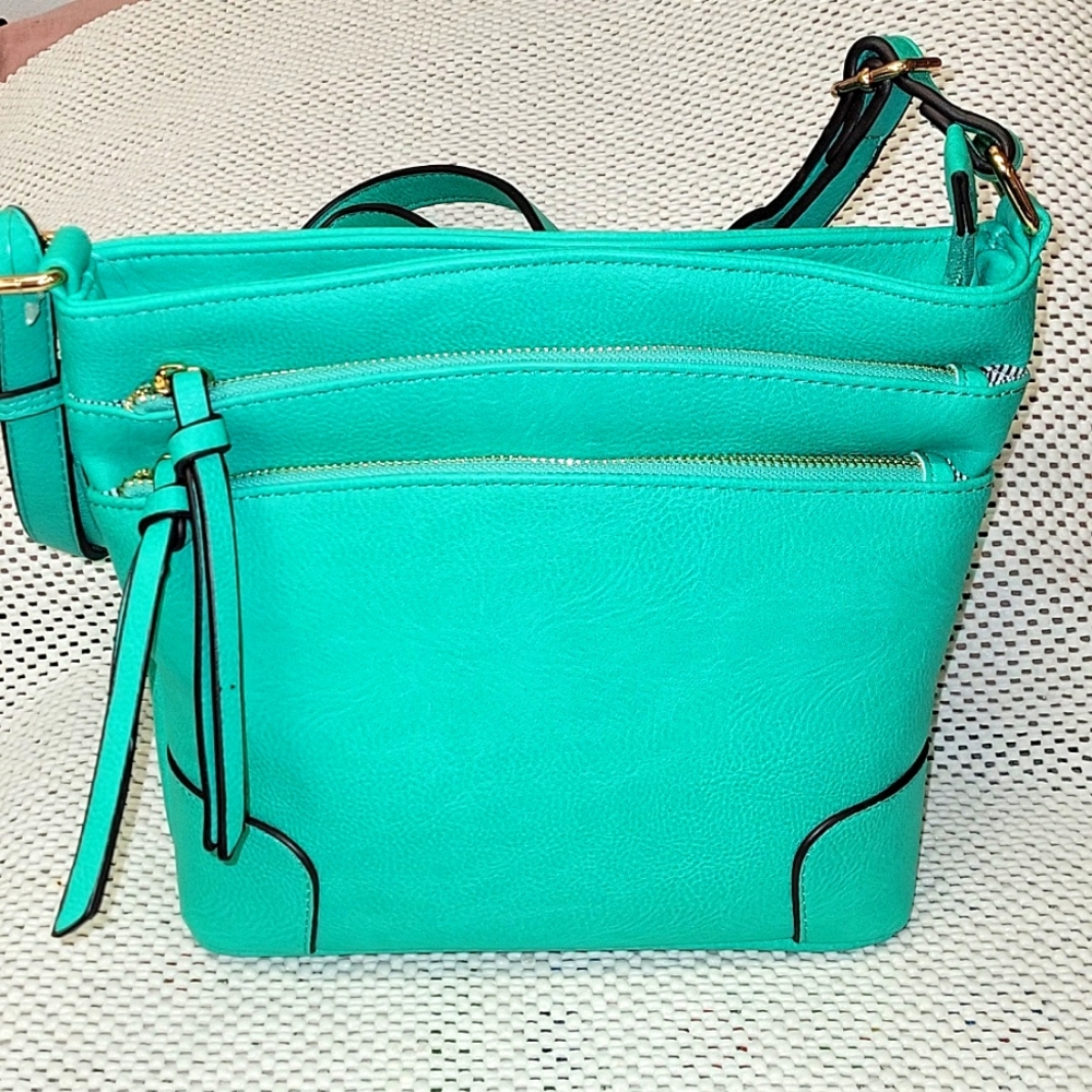 Teal crossbody purse with lots of pockets.